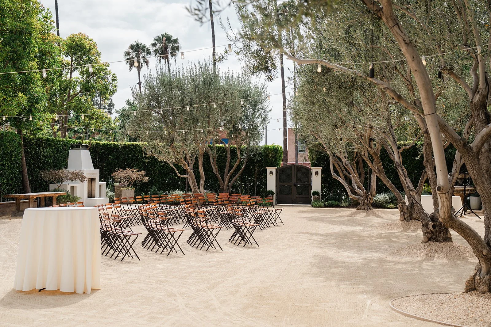 Ceremony aisle and wooden chairs under the olive trees at Grand Gimeno