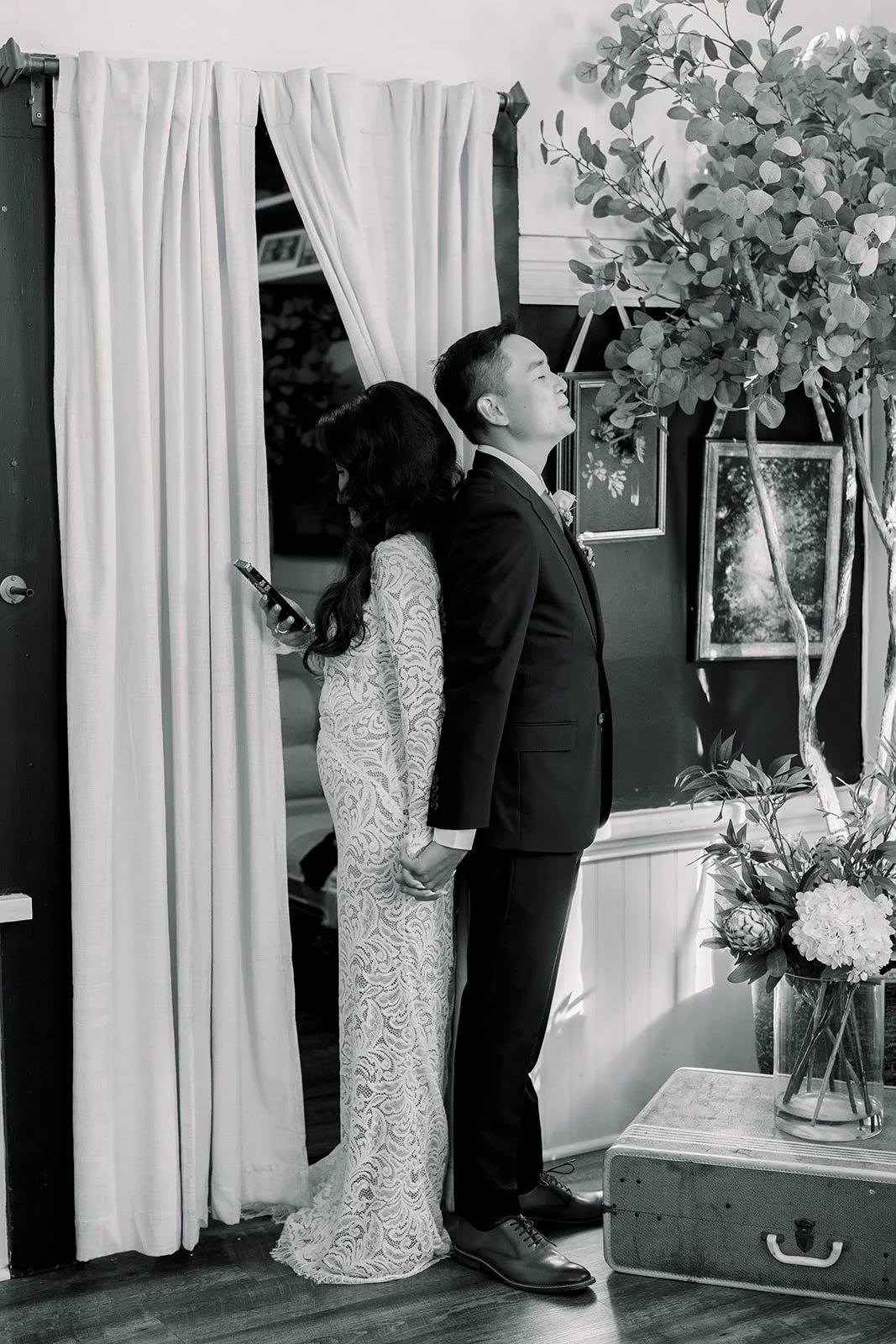 Hannah and Vincent holding hands on either side of a door before the ceremony