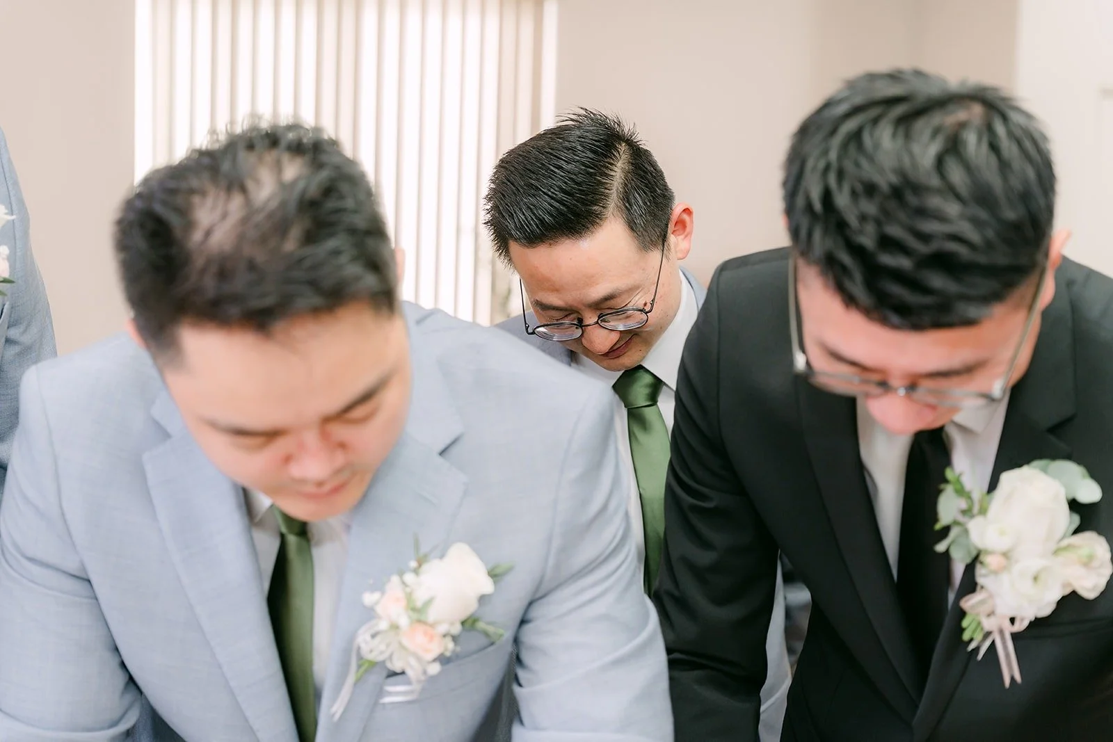 Eric and a groomsman lean in over the table to finish a door game challenge