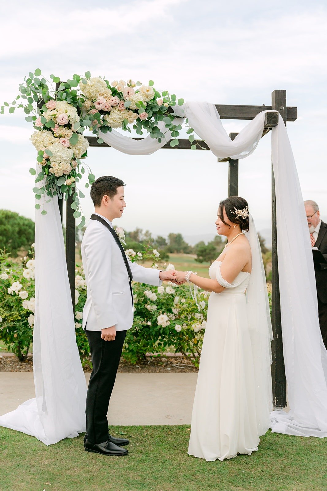 Ivy and Chungman facing each other under the white drapes