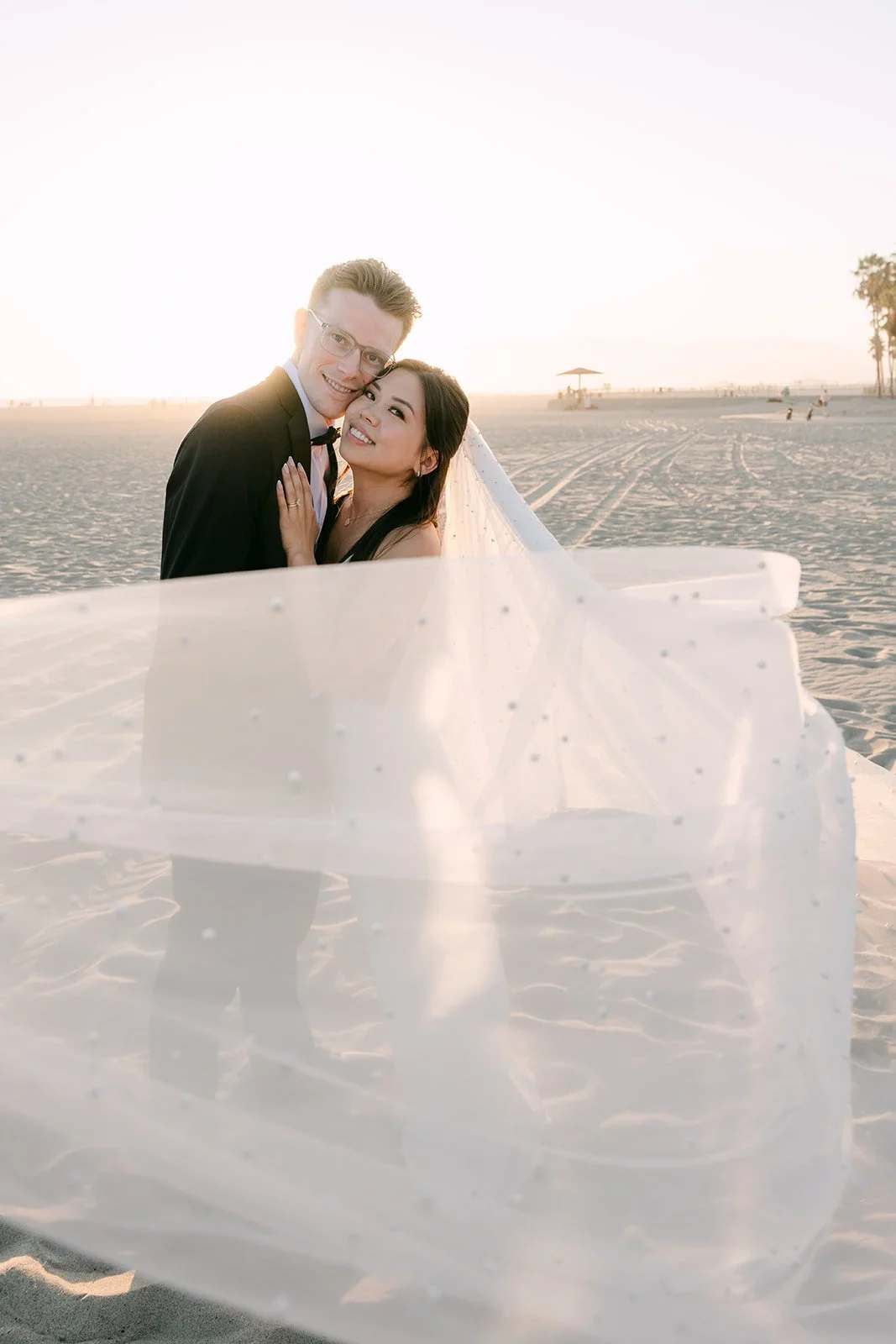 Justine's veil swirling around them on the beach