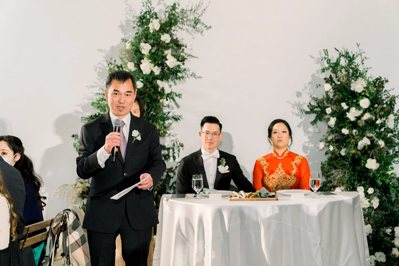 A groomsman gives a speech beside the sweetheart table