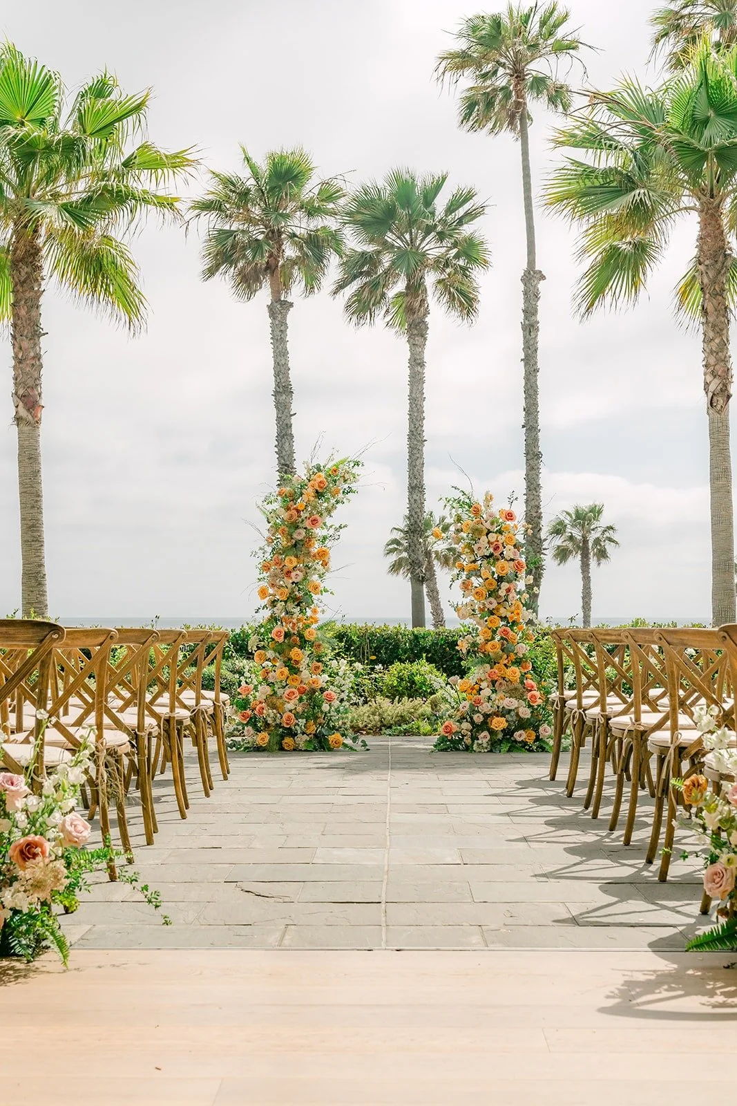 The ceremony aisle on the oceanfront terrace at Seabird Resort, lined with palms and florals