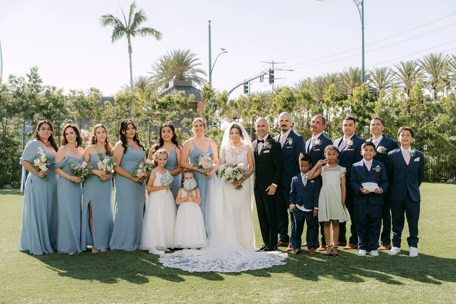 The full wedding party in light blue and navy on the lawn at The Westin Anaheim Resort