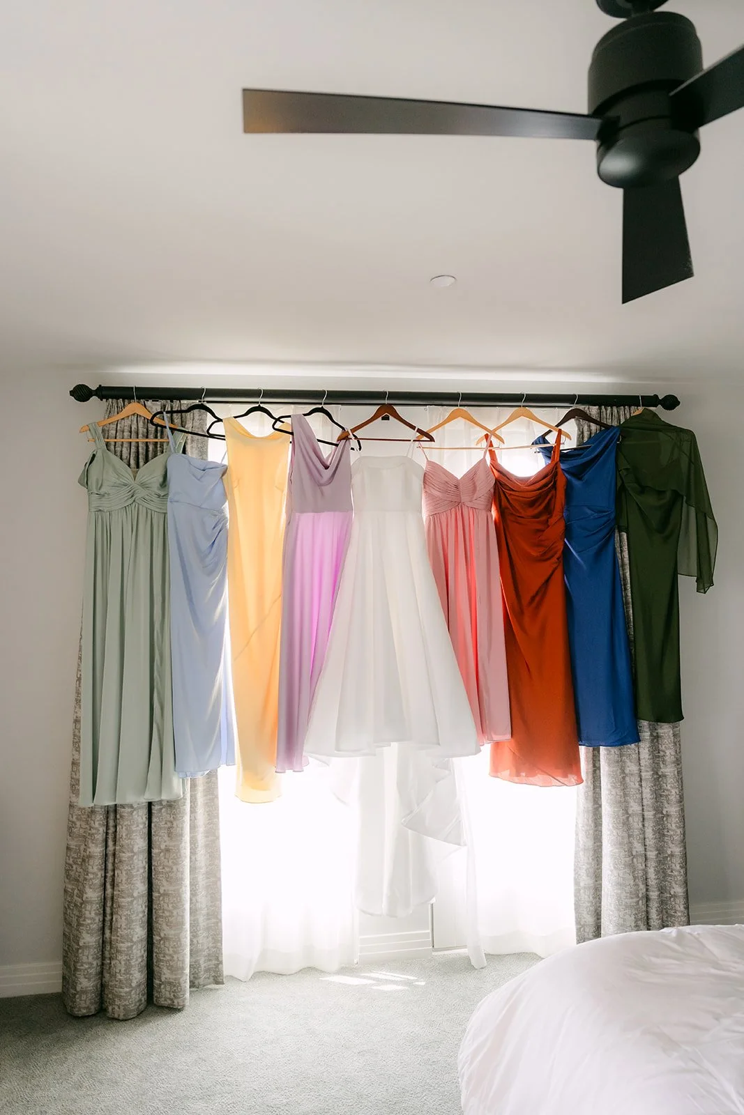 Colorful bridesmaid dresses hanging in the window light at Terranea Resort