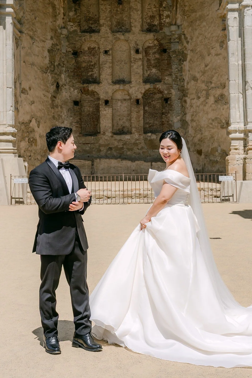 Chorok and Min Soo standing before a carved stone archway in the Mission ruins