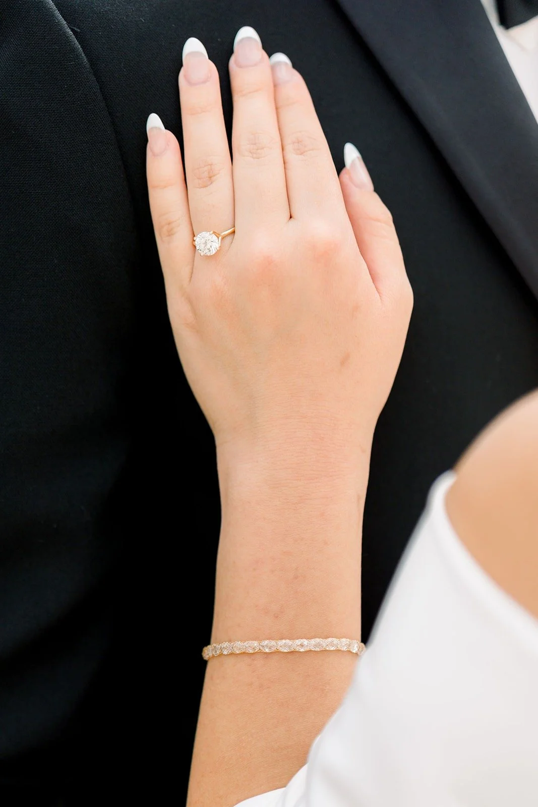 Close up of Jacinda's hand and ring on Steven's lapel