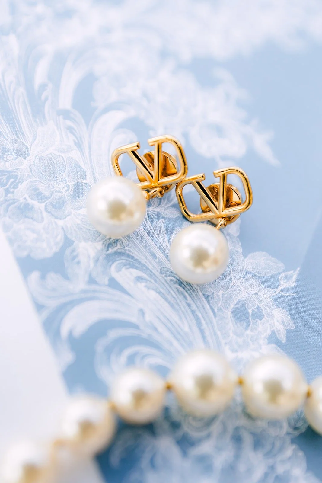 Ivy's pearl earrings on the blue invitation suite