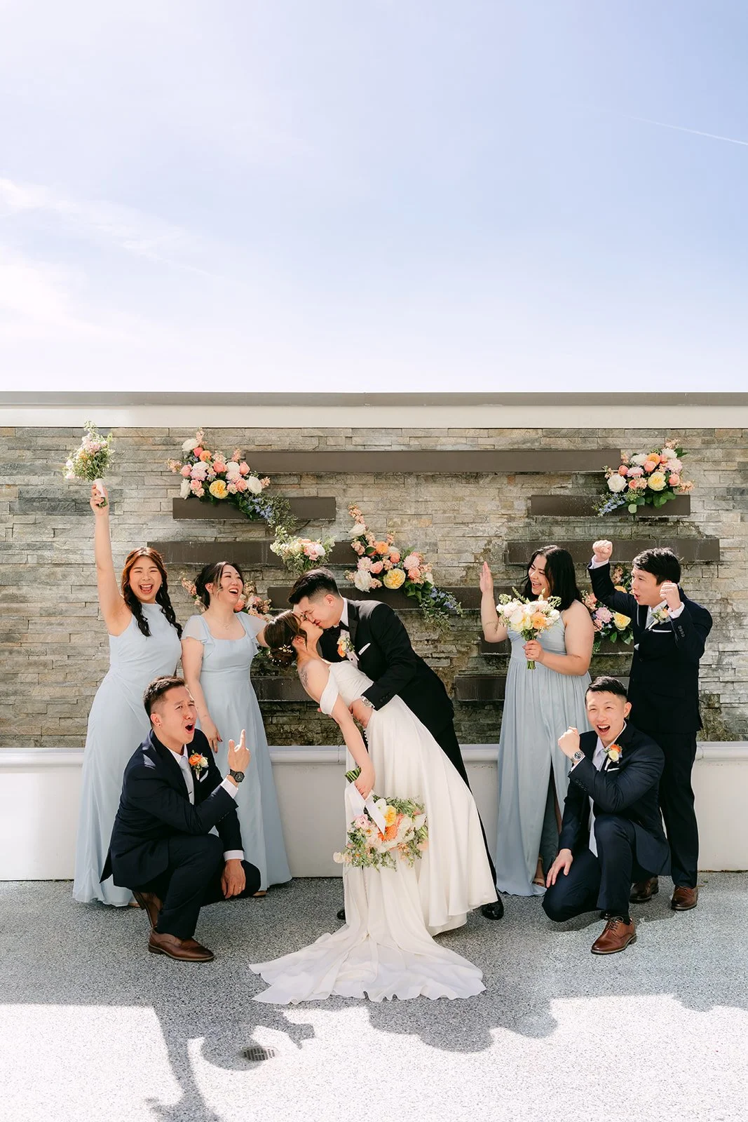 The wedding party in a playful pose around Amanda and San.