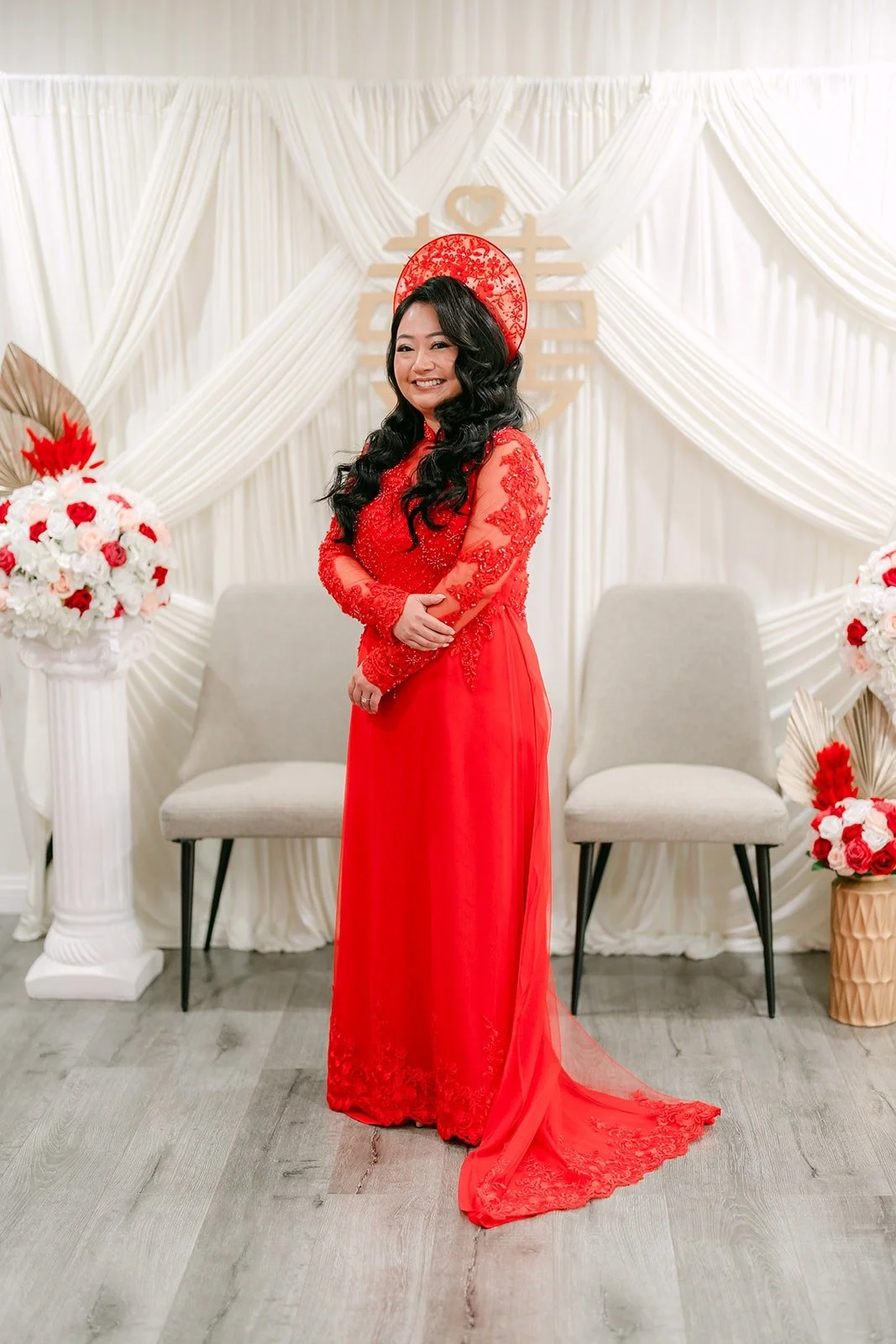 Jennifer in a red lace ao dai with a long train and a red headpiece