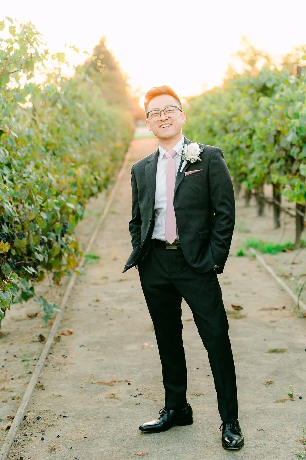 Alex standing in the vineyard at golden hour