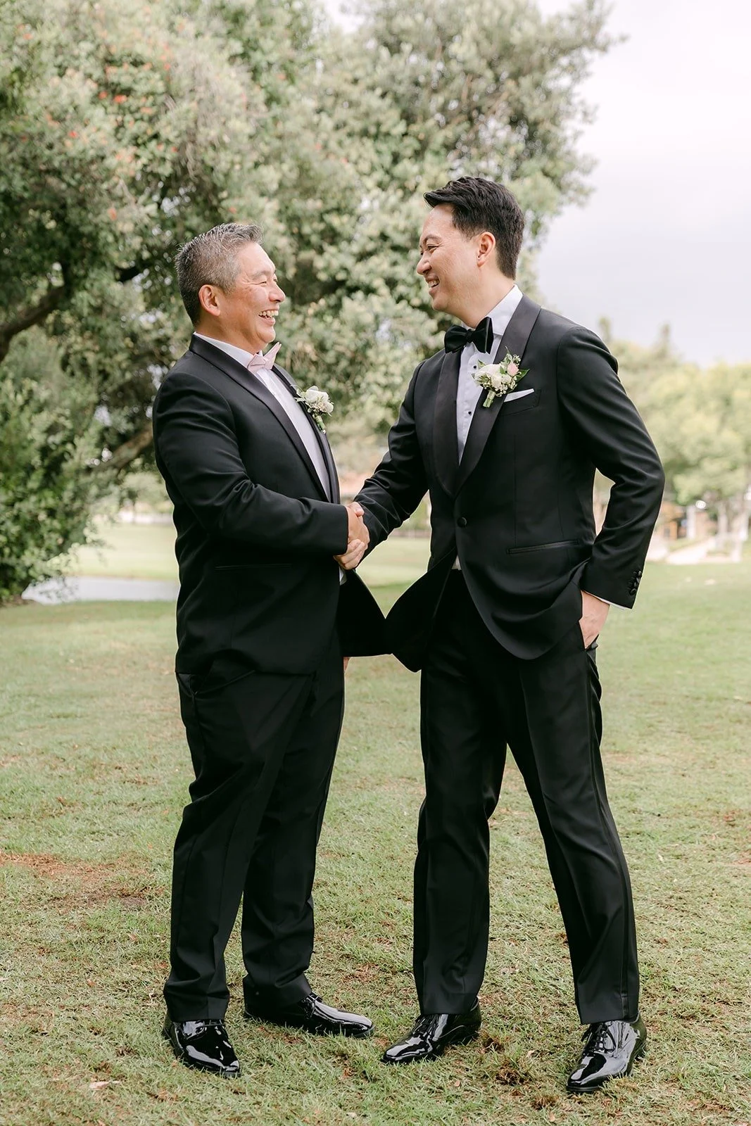 William laughing with a guest in a dark suit on the lawn
