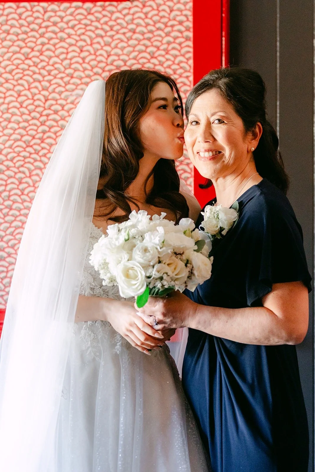 Valerie in her gown kissing a family member on the cheek at Five Crowns