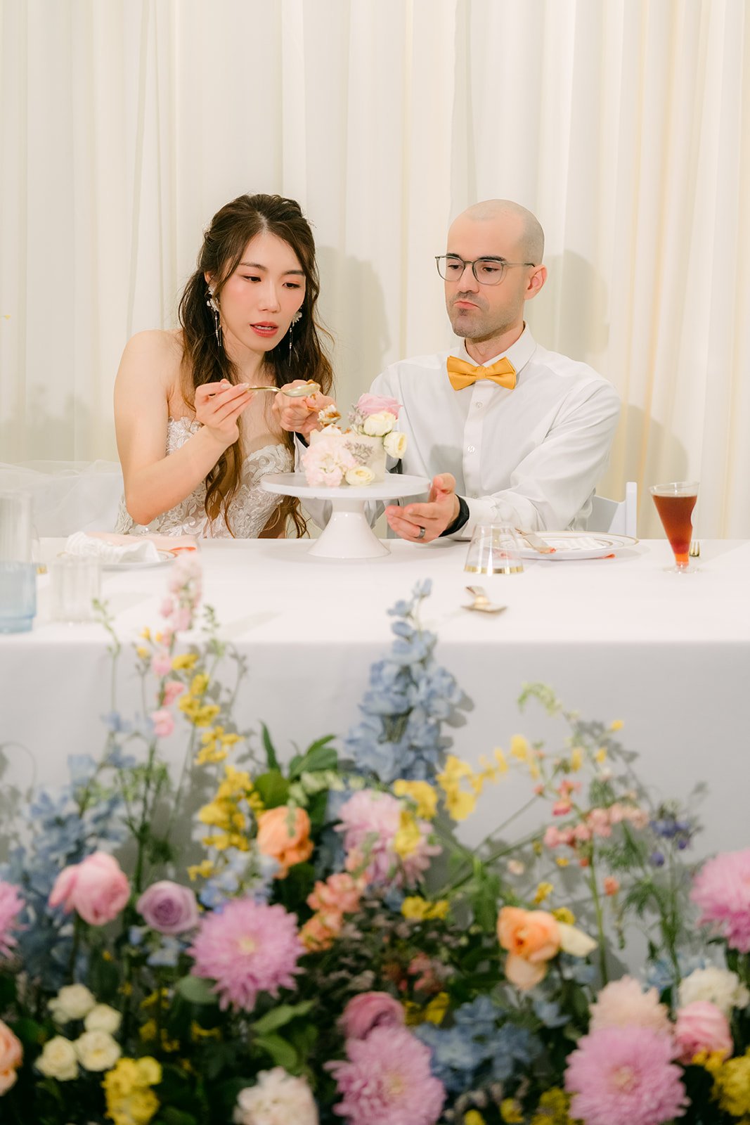 Christie and Christian cutting their cake at the sweetheart table.