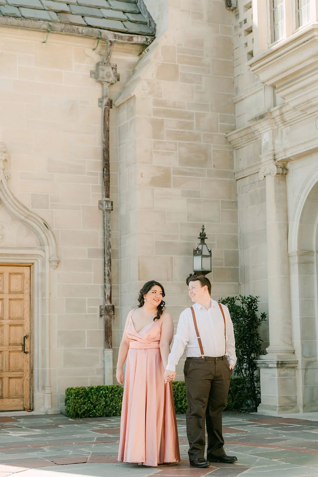 The couple at the mansion's side entrance with its Gothic-style doorway.