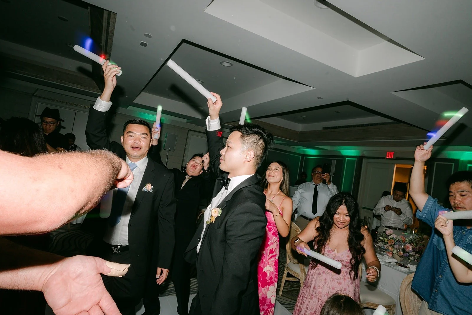 Friends dancing with light up sticks on the dance floor