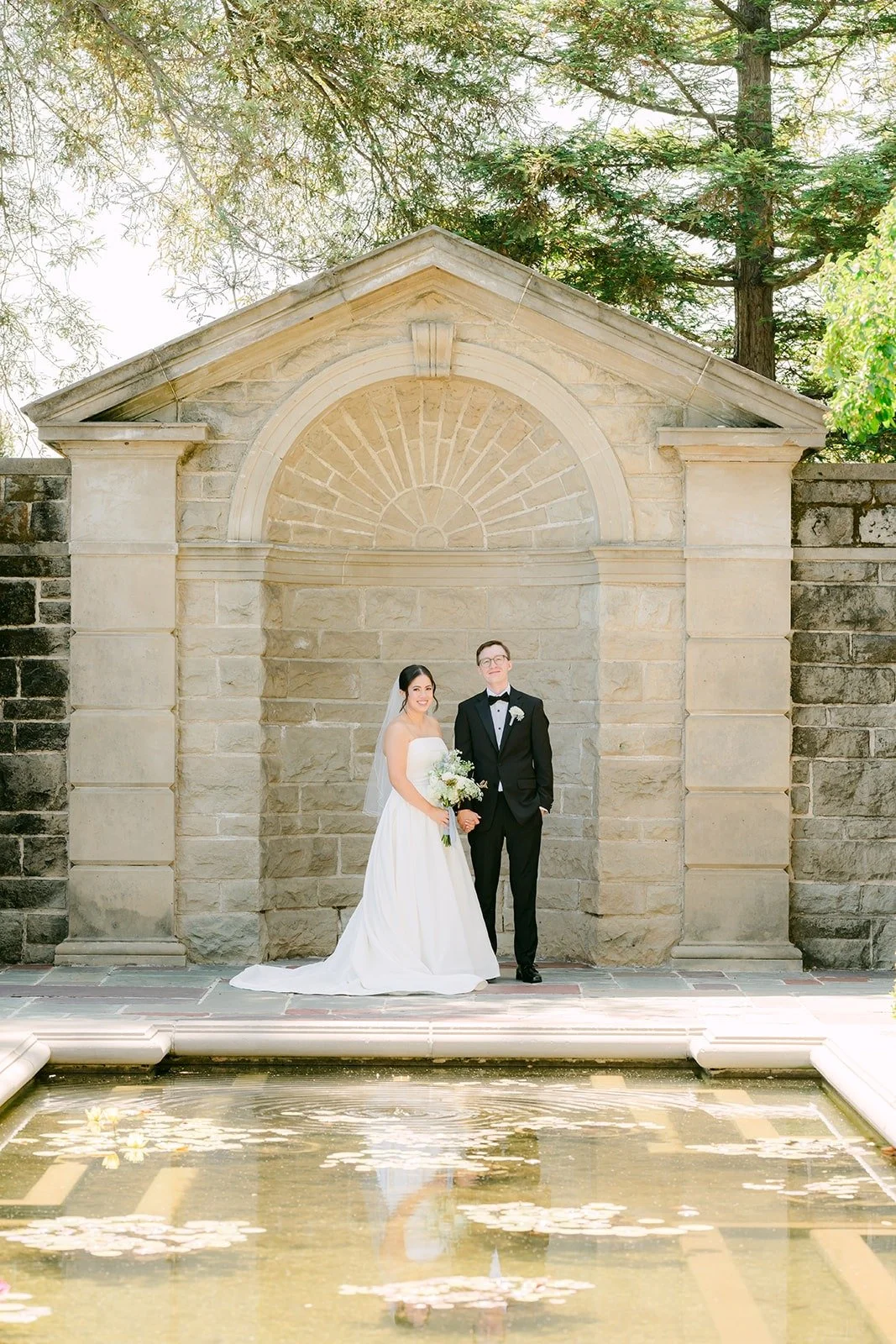 Brianna and Nik at the reflecting pool and stone pavilion at Greystone Mansion