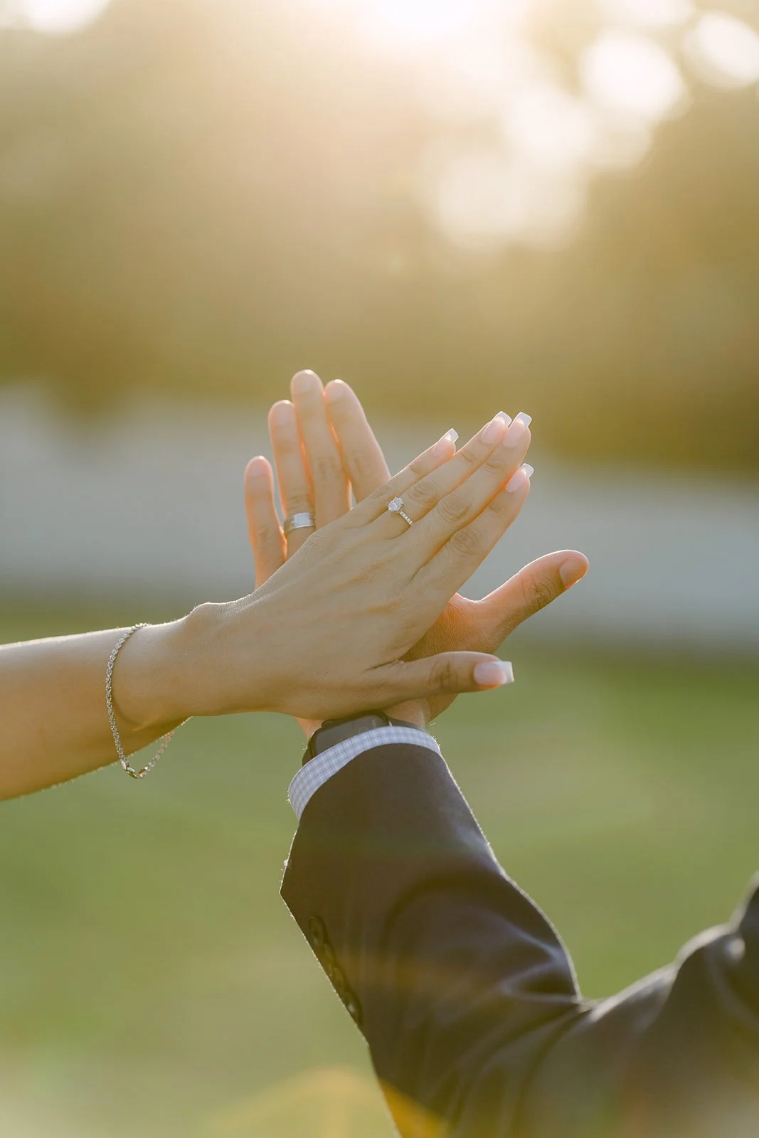 Francesca and Daniel's hands reach together against the setting sun.