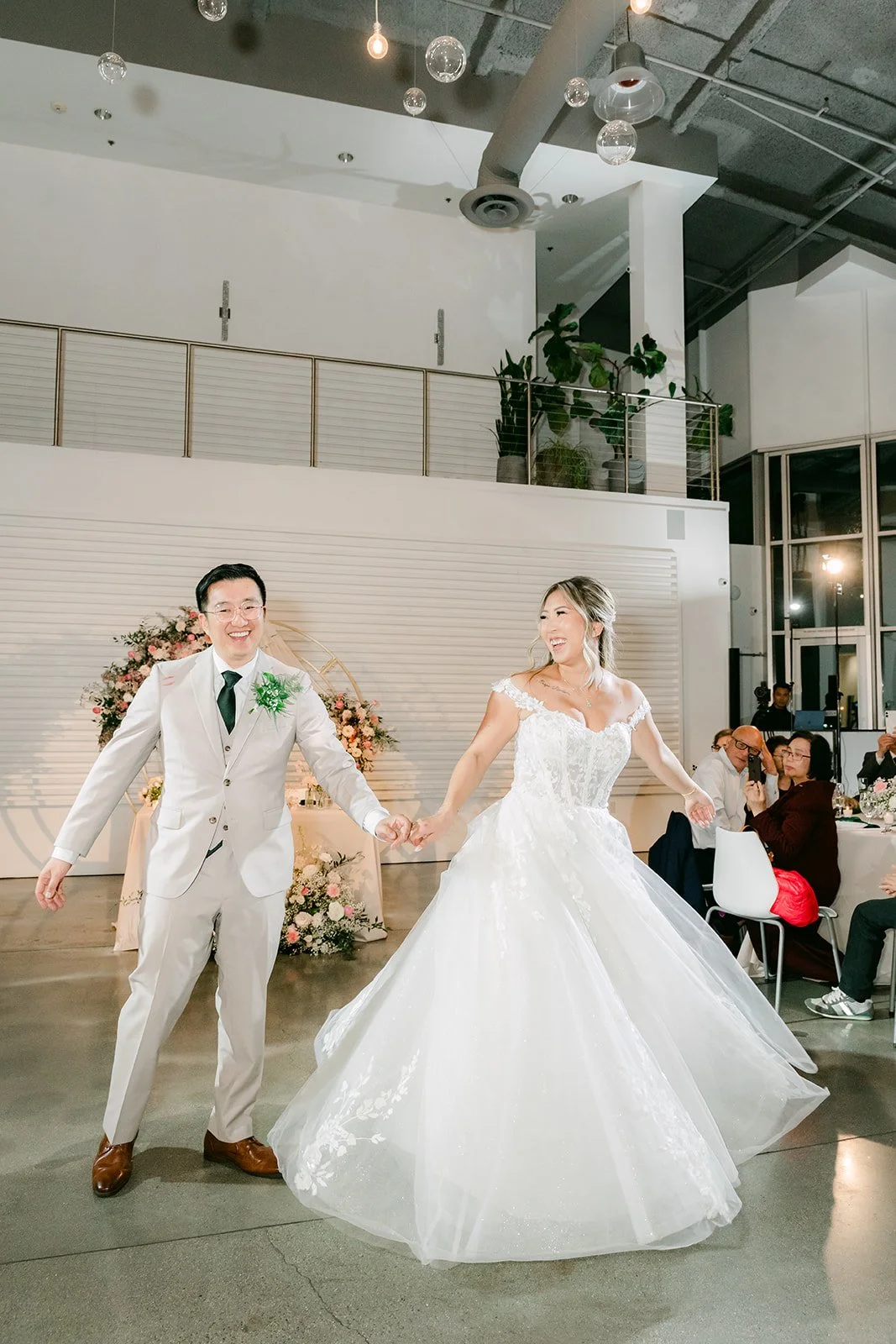 Newlyweds dancing in front of the floral arch