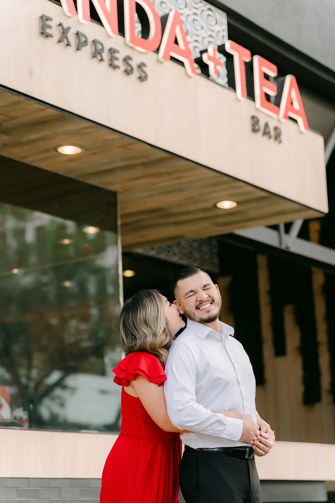 Linh and Ankush share a laugh under the restaurant sign.