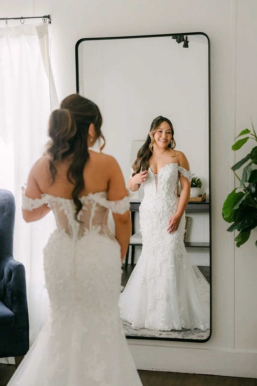 Nicole in her lace gown checking her reflection in the cottage mirror.