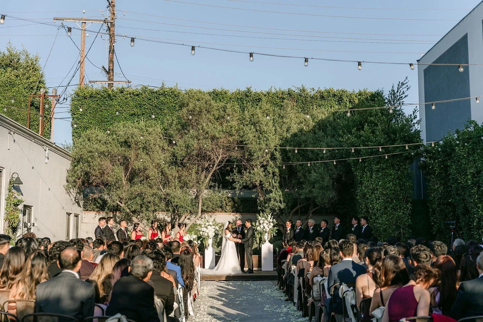 Wide view of the outdoor ceremony at The Harper with guests filling both sides of the aisle