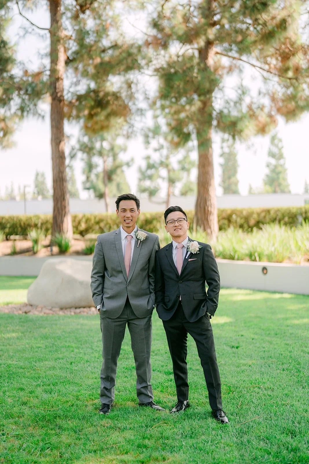 Alex and a groomsman standing under the pine trees at the Turnip Rose