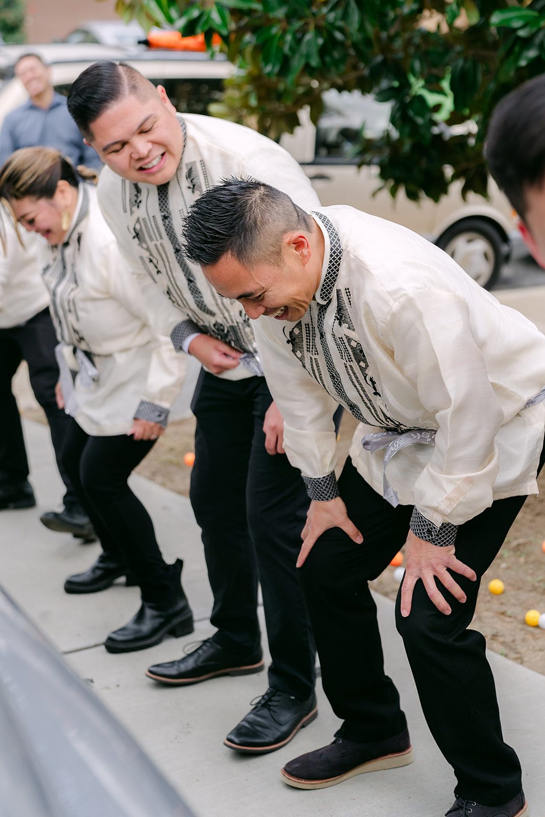 Groomsmen bent over laughing as they take on the first door game challenge.