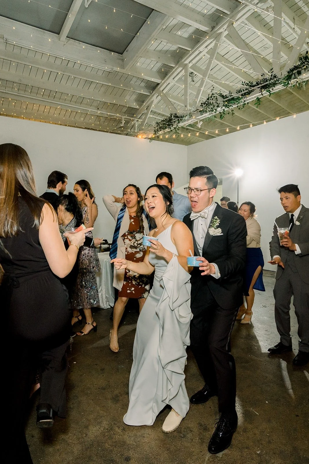 Cindy and Alex dance with friends under the warehouse ceiling of The East Angel