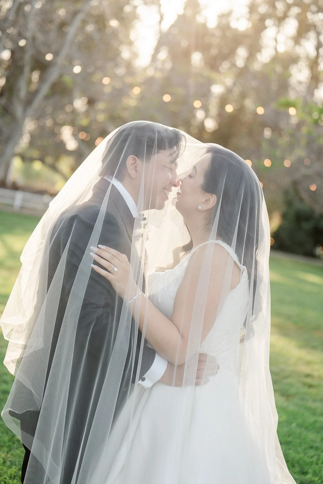 Under the veil kiss in golden hour light at The Walnut Grove