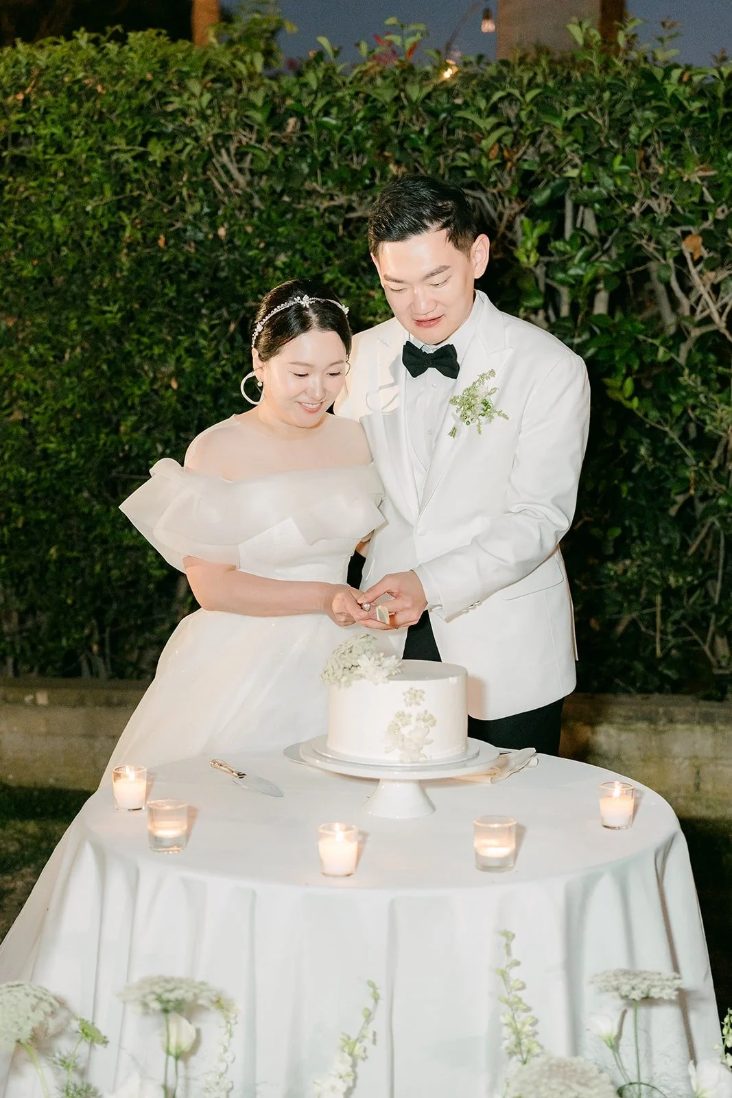 Amy and Sam cutting the cake by candlelight