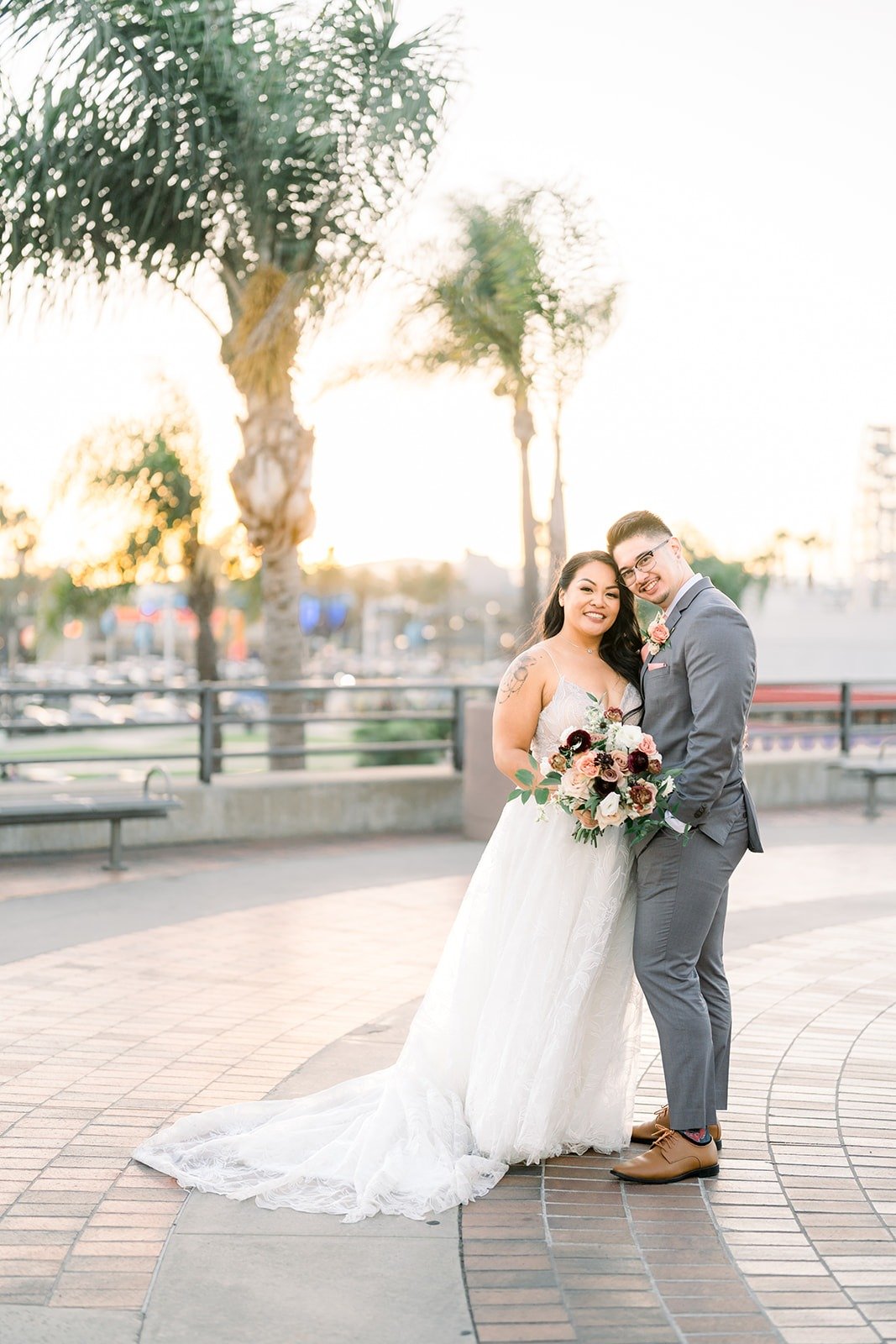 Betsy and Mikey on a palm lined brick plaza at sunset