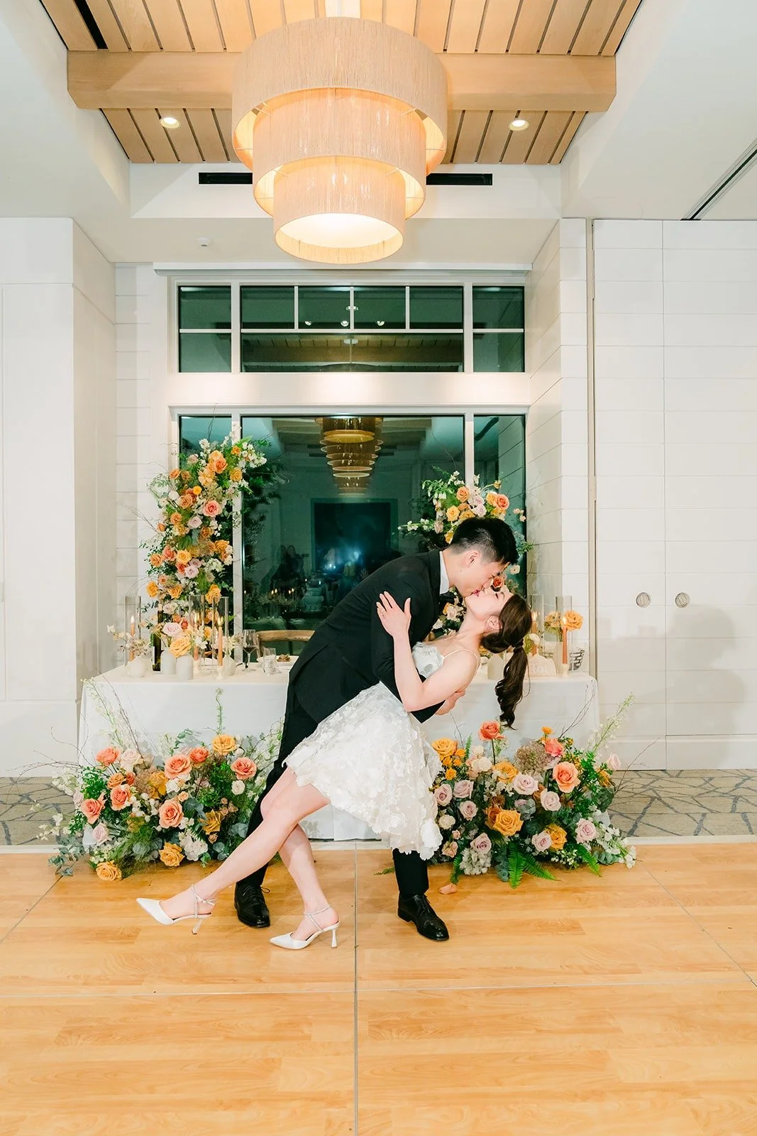 Eli dipping Angela on the ballroom floor in front of the sweetheart table