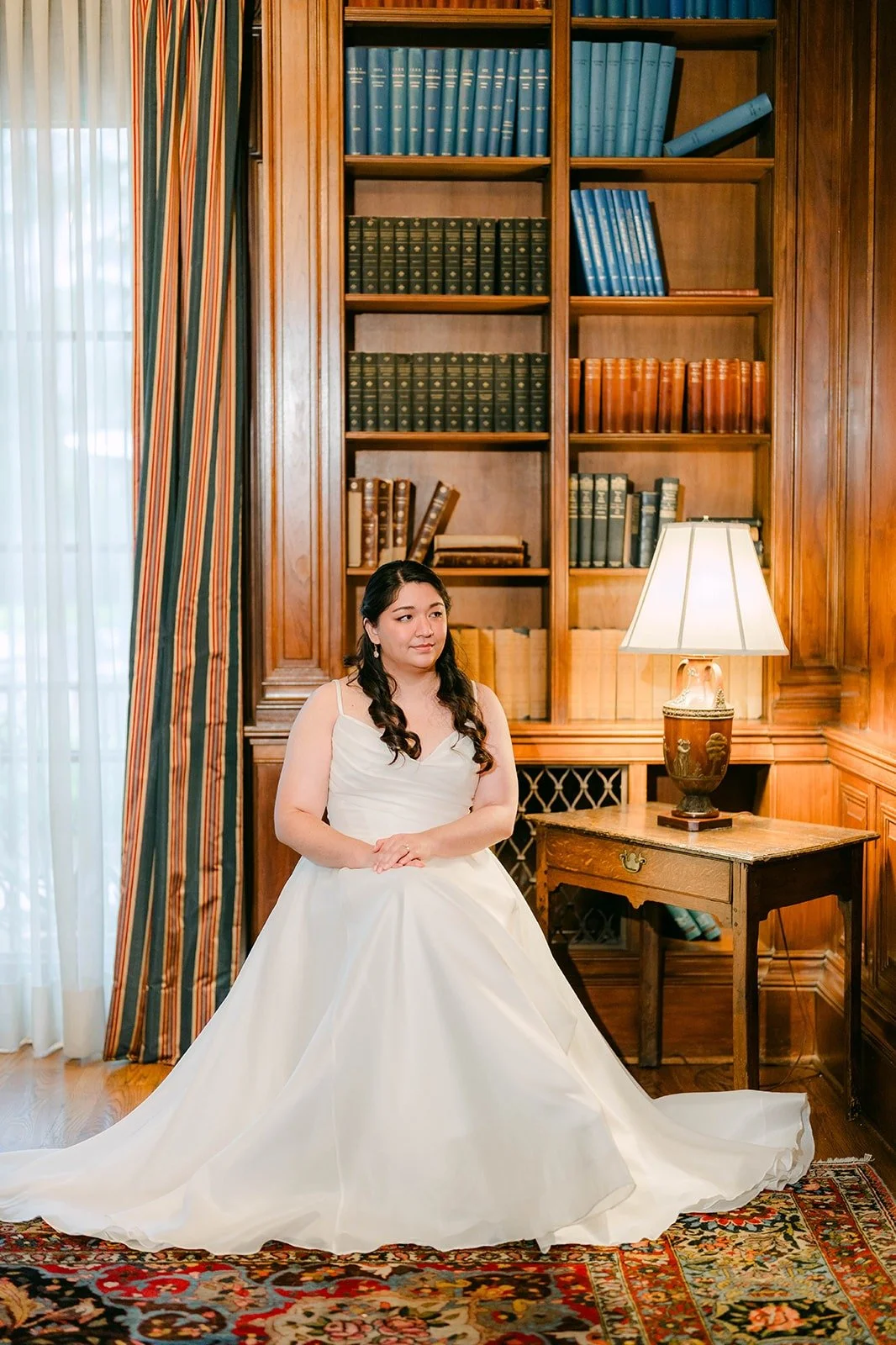 Saira seated in the wood paneled library at The Athenaeum