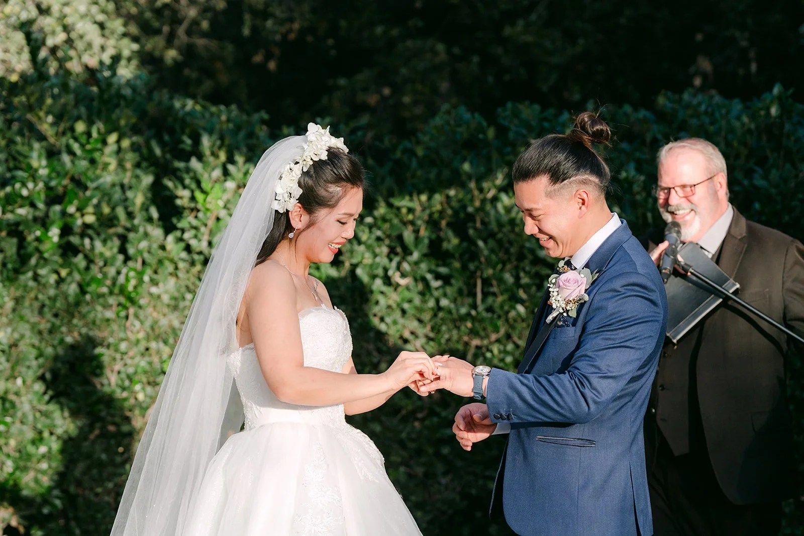 Kate and Michael smiling during the ceremony with their officiant.