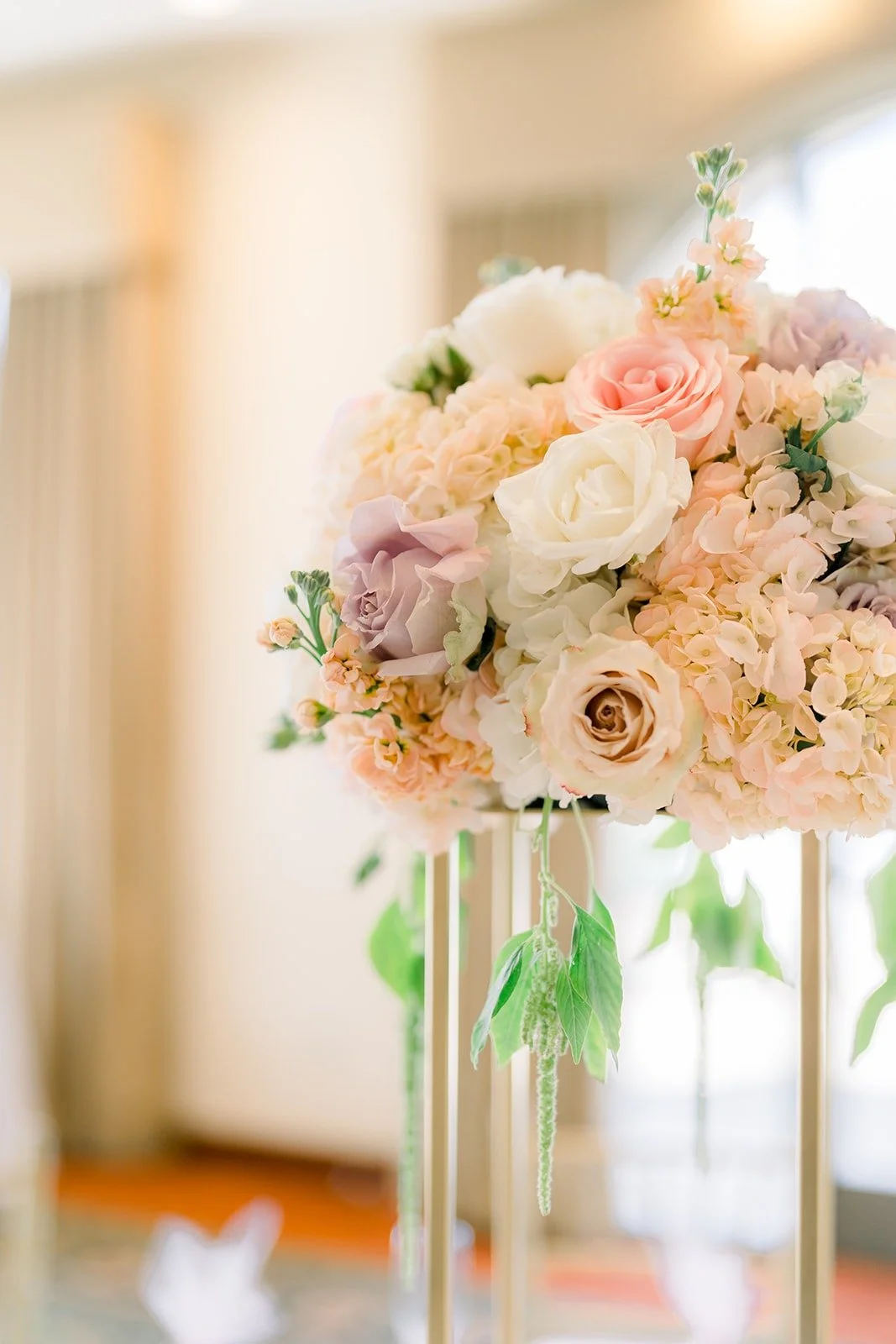 Tall blush and white rose centerpiece on a gold stand