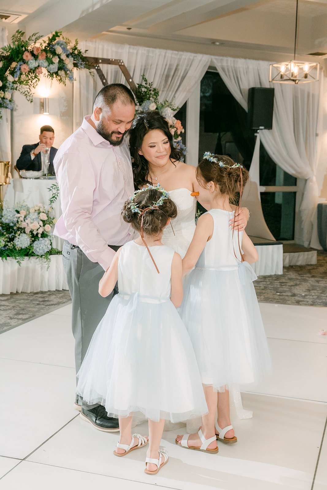 A guest dancing with two flower girls