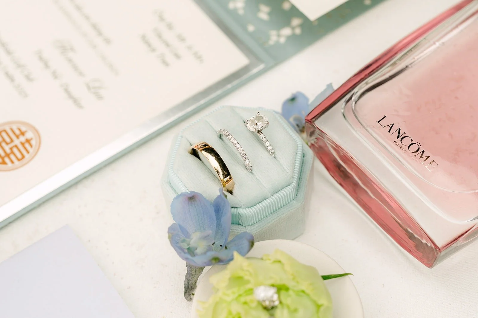 Rings in the blue ring box with perfume and blue flowers