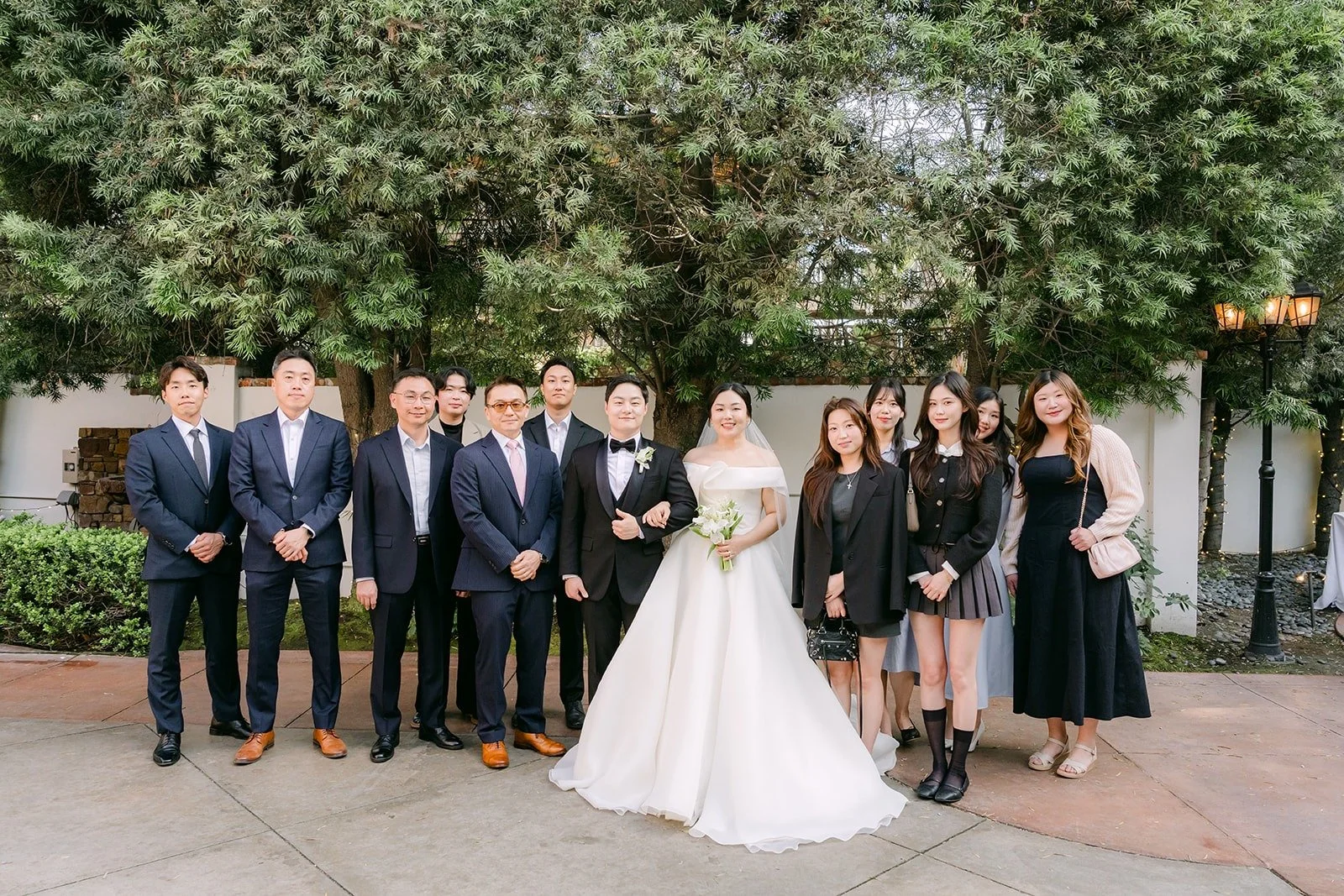 Chorok and Min Soo with a large group of friends in the courtyard, photographed by One and Only Production