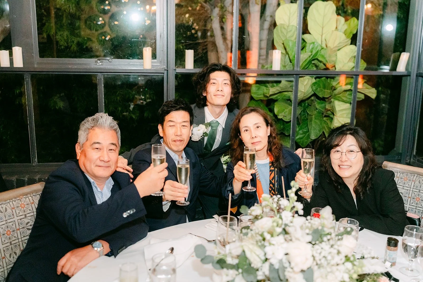 Valerie and Jason toasting with family members at their table