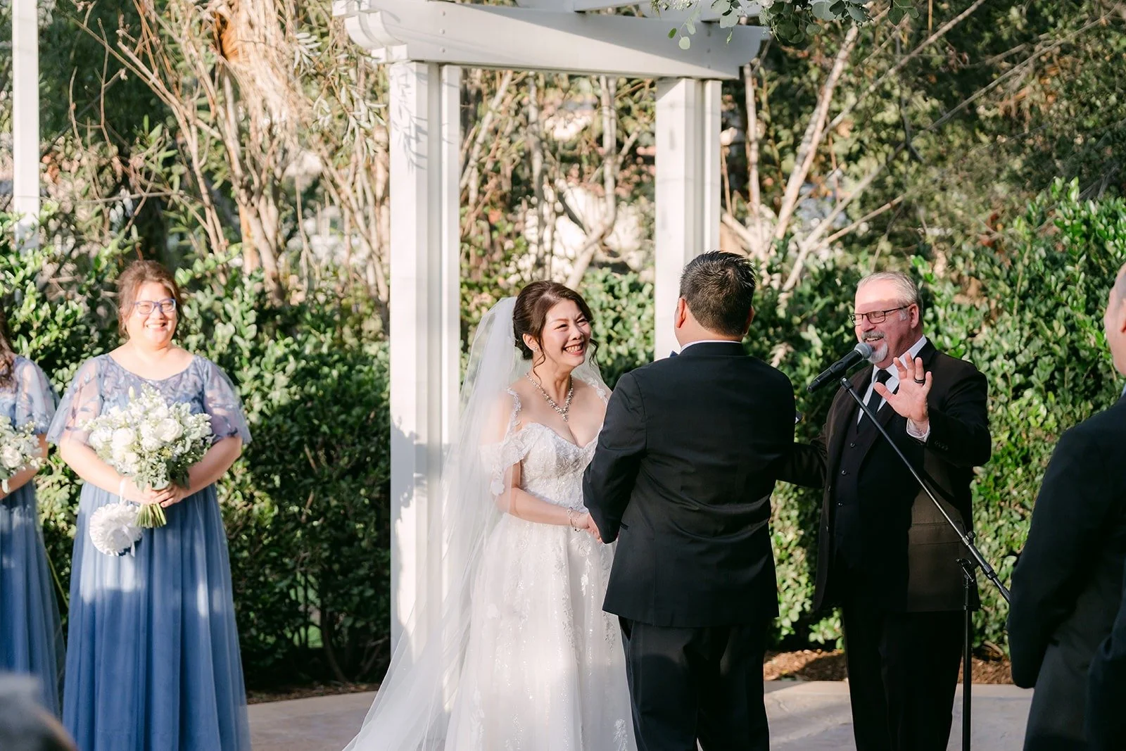 Sochi and Jay at the arbor beside the bridesmaids and groomsmen
