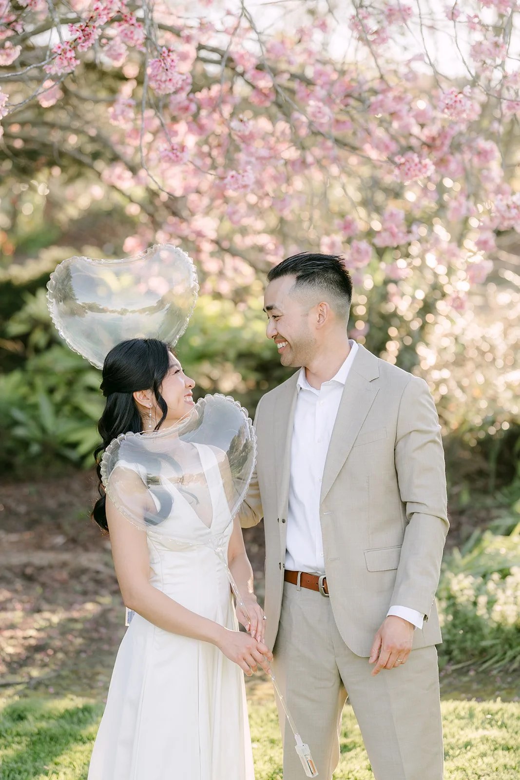 Kim and Vincent holding hands in front of the blossoms, photographed by One and Only Production.