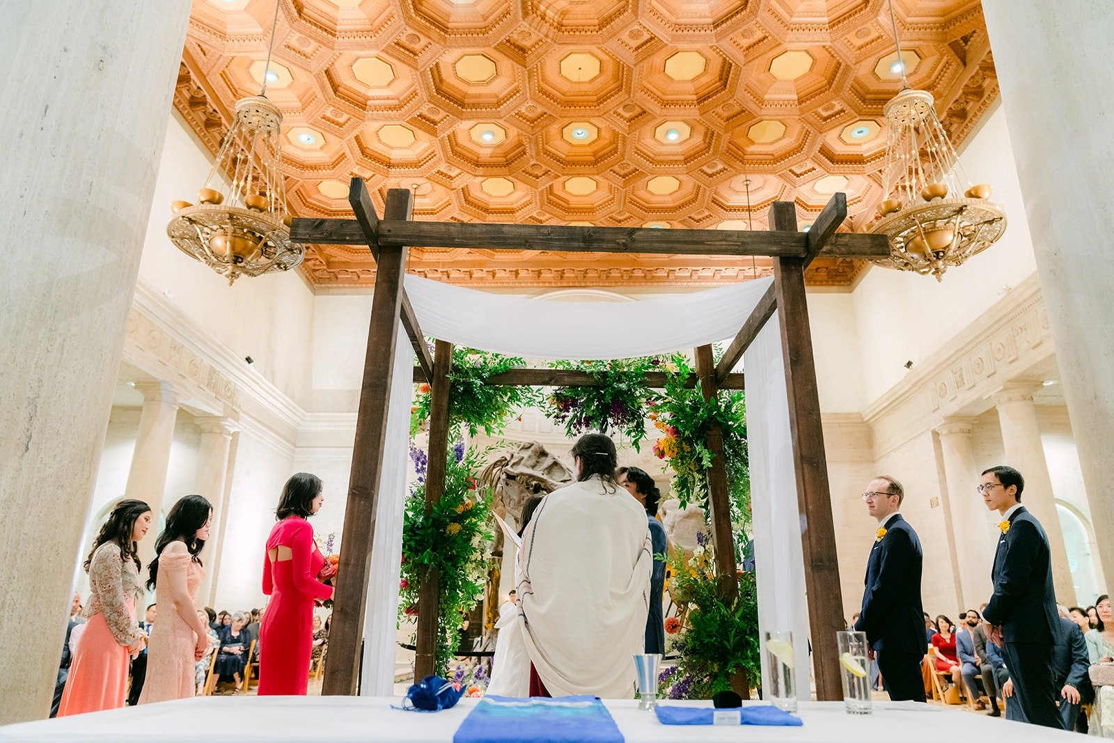 A wide view of the ceremony under the coffered ceiling