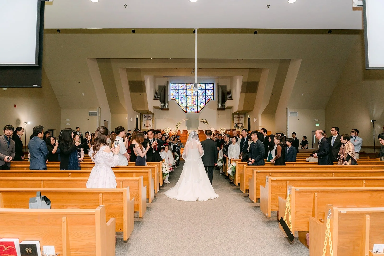 Eunice and her father walk down the aisle in the full sanctuary