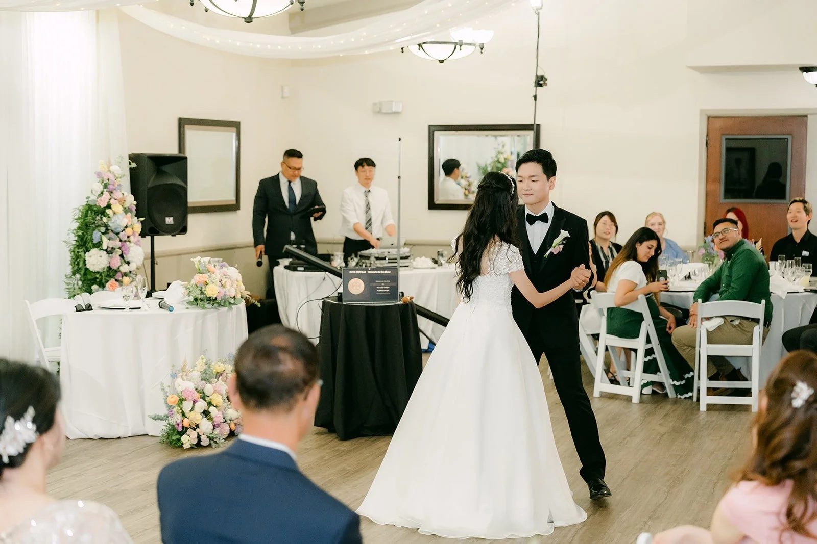 Jeannie and Eunsang beginning their first dance as guests watch