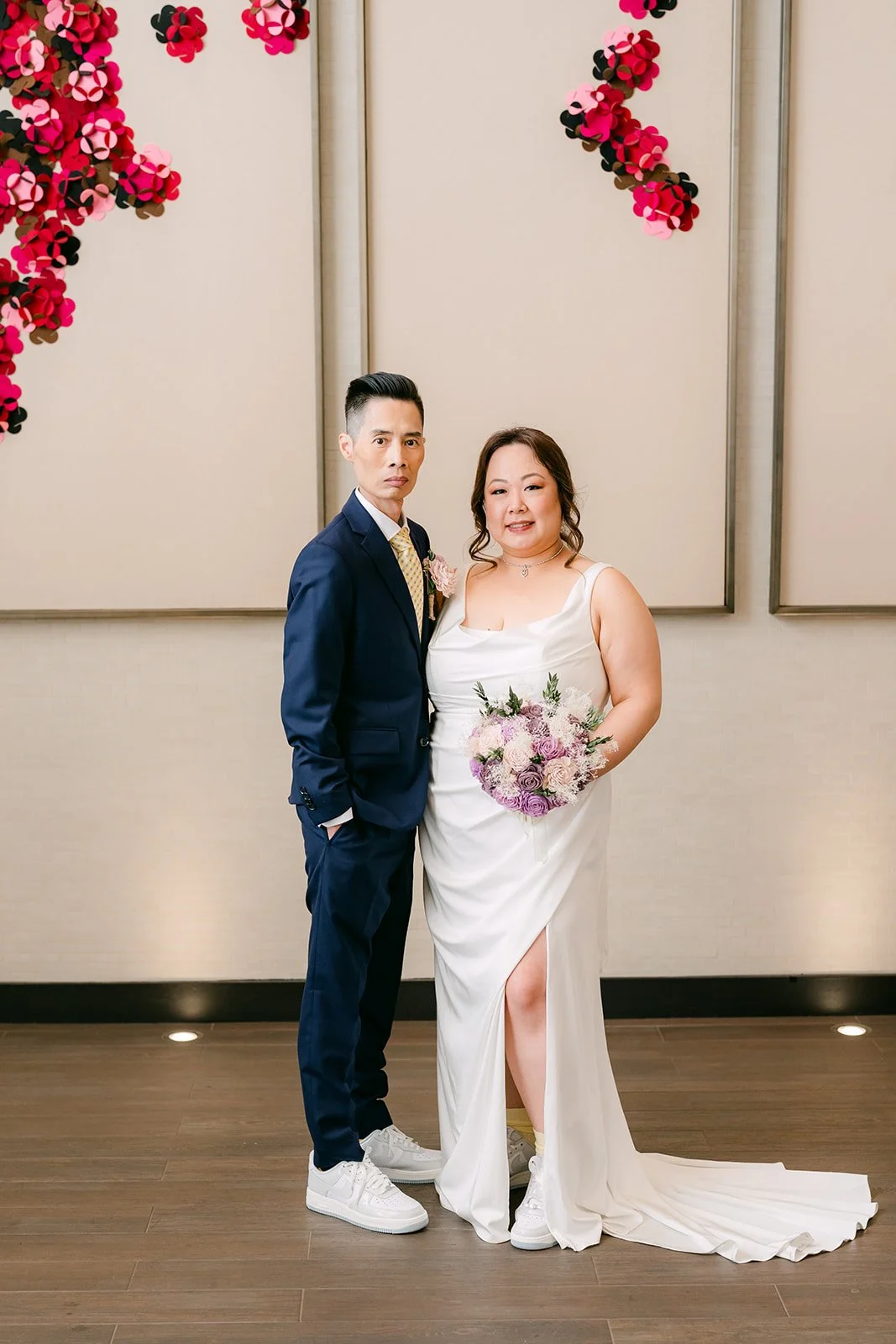 Mai and Bobby in front of the red floral wall.