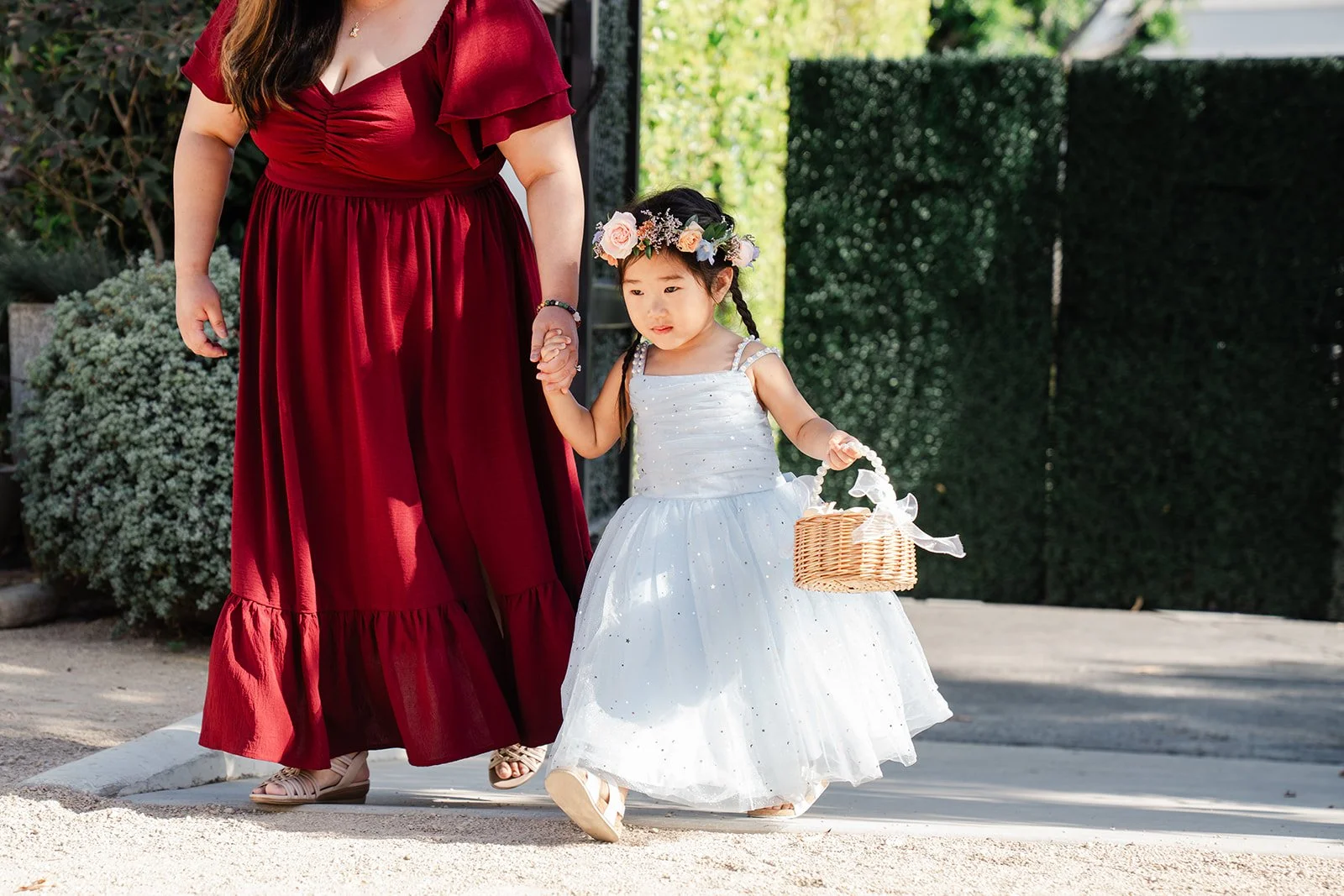 Flower girl in white walking down the aisle