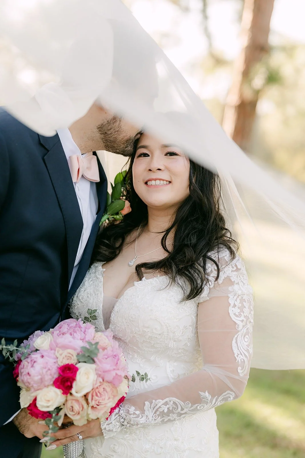 Amy laughing under her veil with James close behind