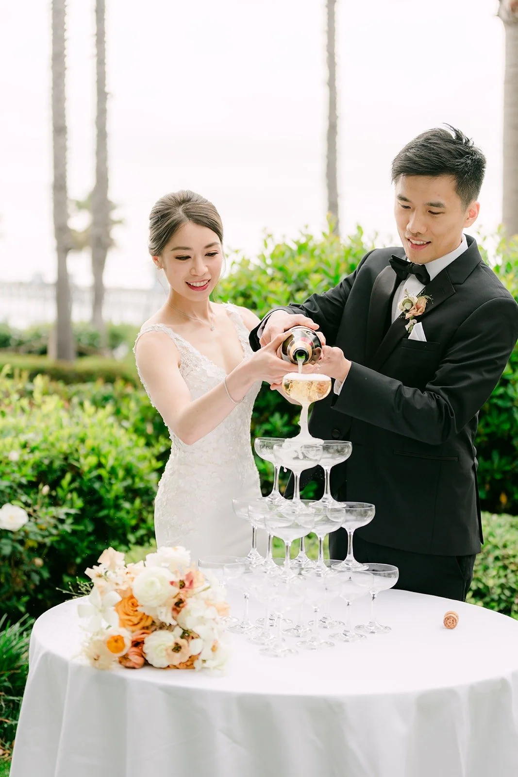 Angela and Eli pouring champagne over the tower together
