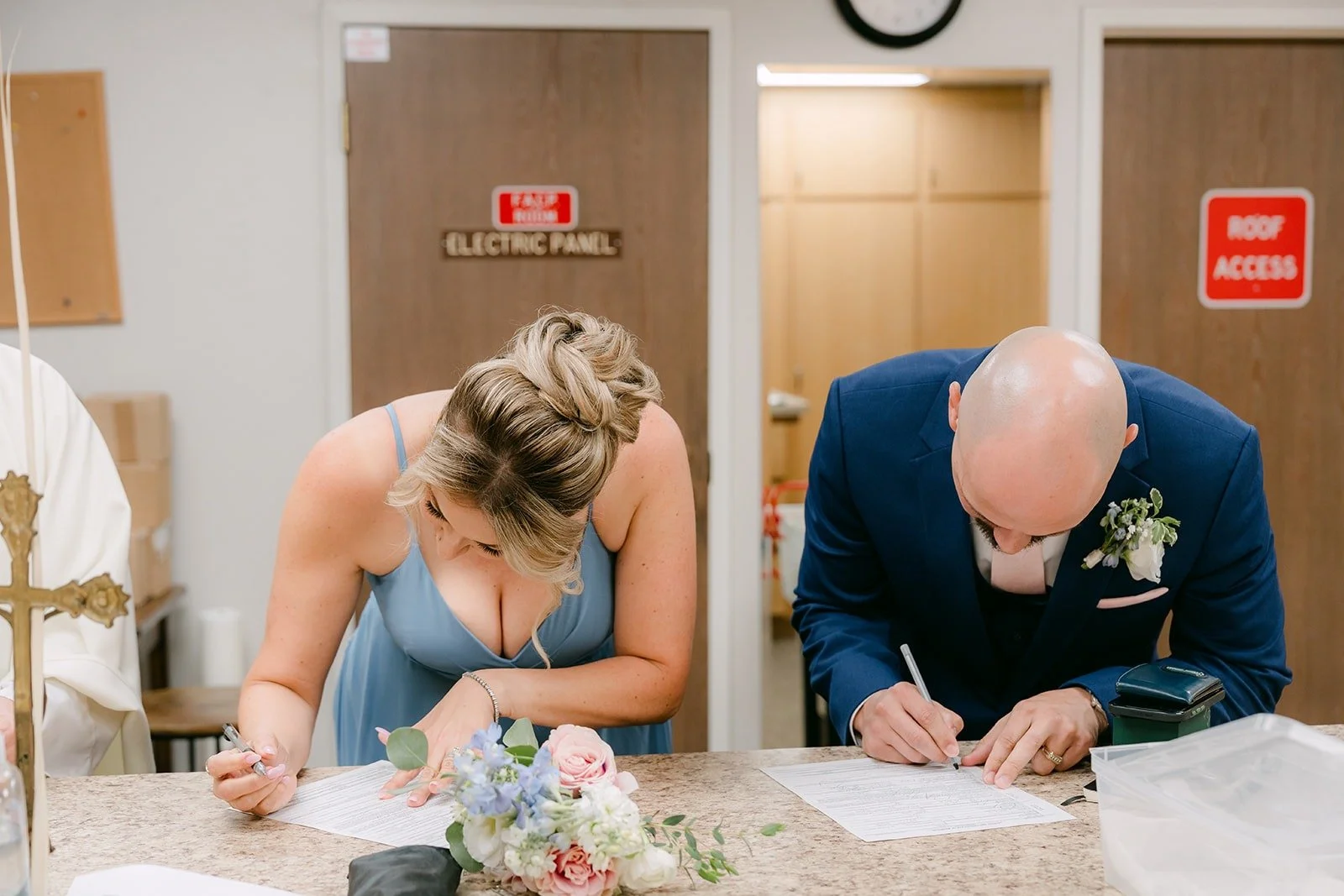 The sponsors sign the marriage license in the sacristy